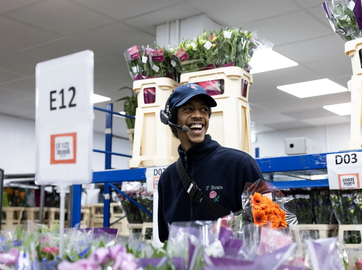 A picker at Tom Brown Wholesale wearing a voice headset, collecting stock from a labelled location